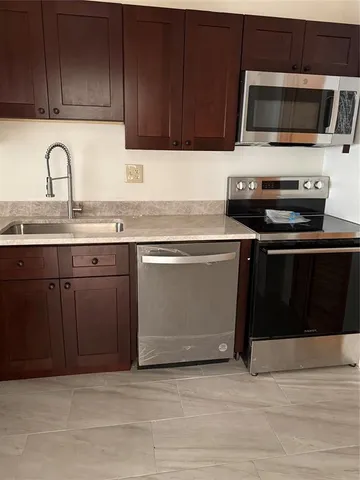 a kitchen with stainless steel appliances granite countertop a stove and a microwave