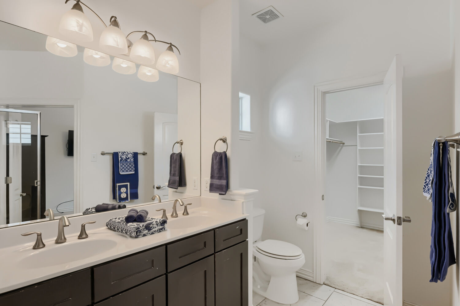 6715 Windrift Way, Unit 28 Austin, TX 78745 - Photo 15 of 19 Primary bathroom features a dual vanity, sleek dark cabinetry, and ample storage.
