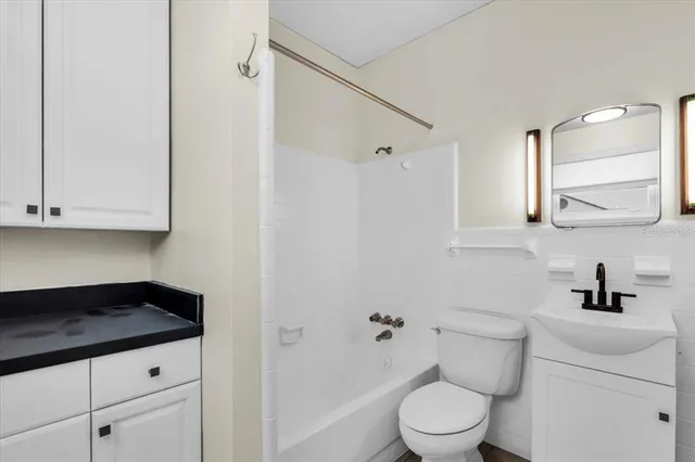 a bathroom with a granite countertop sink a toilet and shower