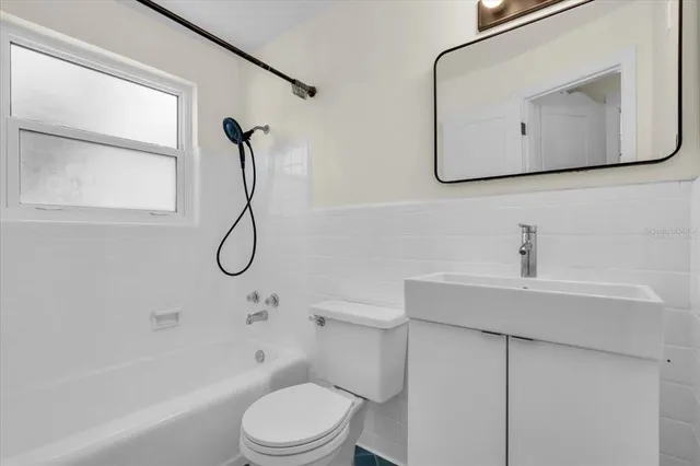 a bathroom with a toilet a sink a mirror and shower