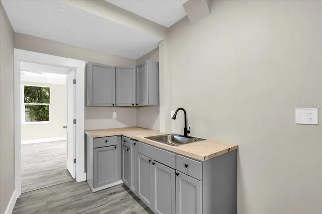 a kitchen with a sink cabinets and wooden floor