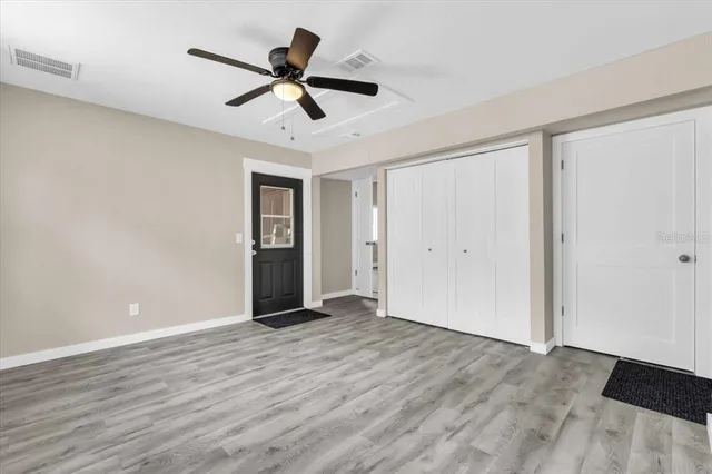 a view of empty room with wooden floor and ceiling fan