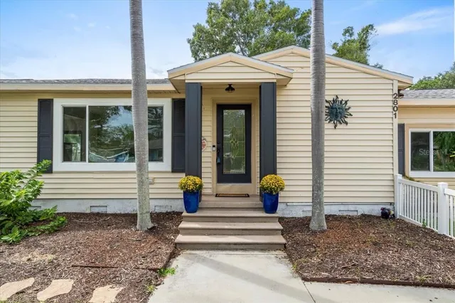 a front view of a house with potted plants