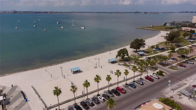 a view of road with card parked on side and retail shops