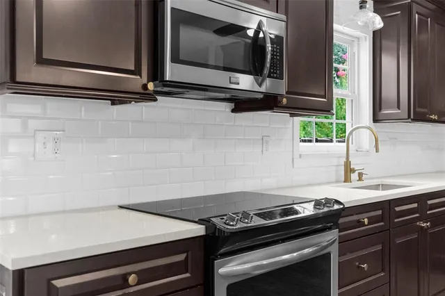 an empty room with wooden floor chandelier and windows