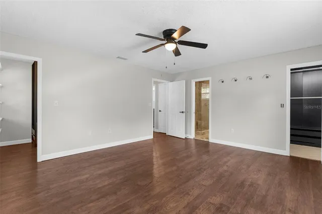 a view of an empty room with a ceiling fan