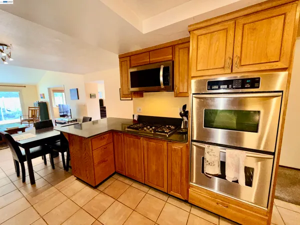 a large kitchen with stainless steel appliances a stove a sink dishwasher and cabinets