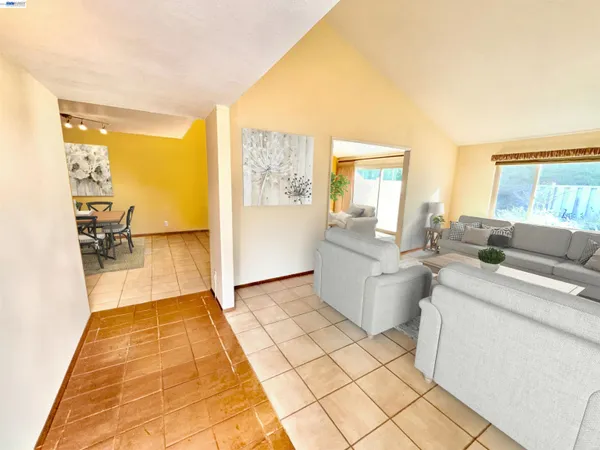 a living room with furniture a flat screen tv and a table