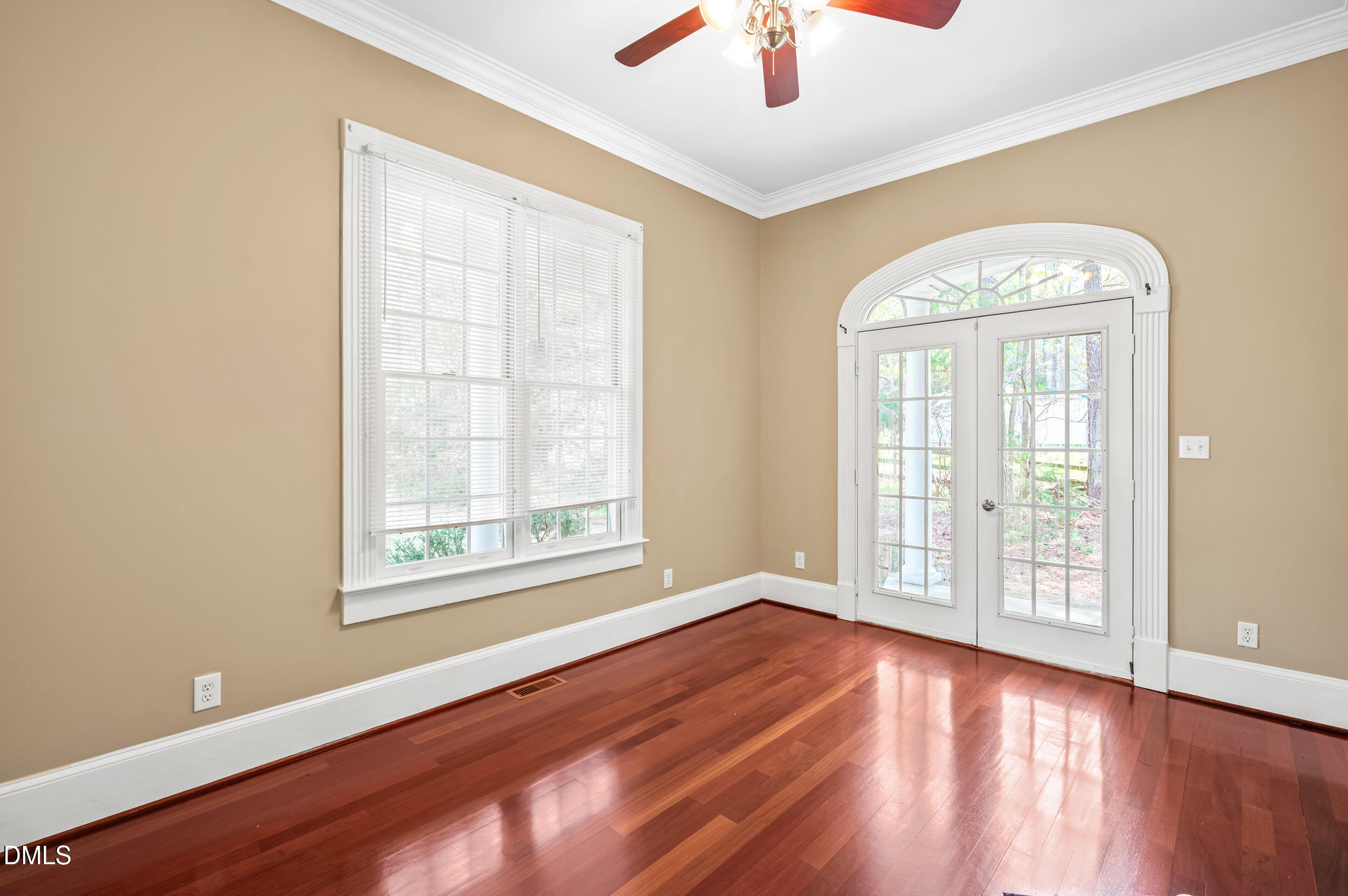 1957 Hilltop Road Raleigh, NC 27610 - Photo 7 of 46 an empty room with wooden floor fan and windows