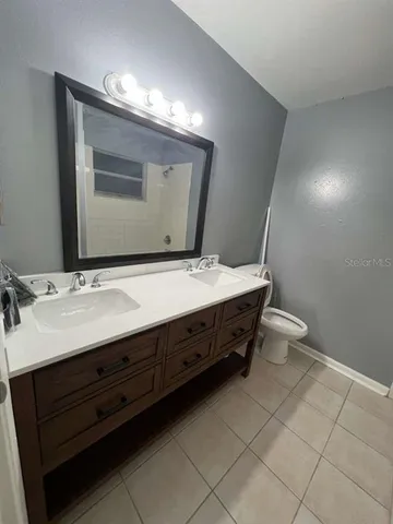 a bathroom with a double vanity sink mirror and toilet