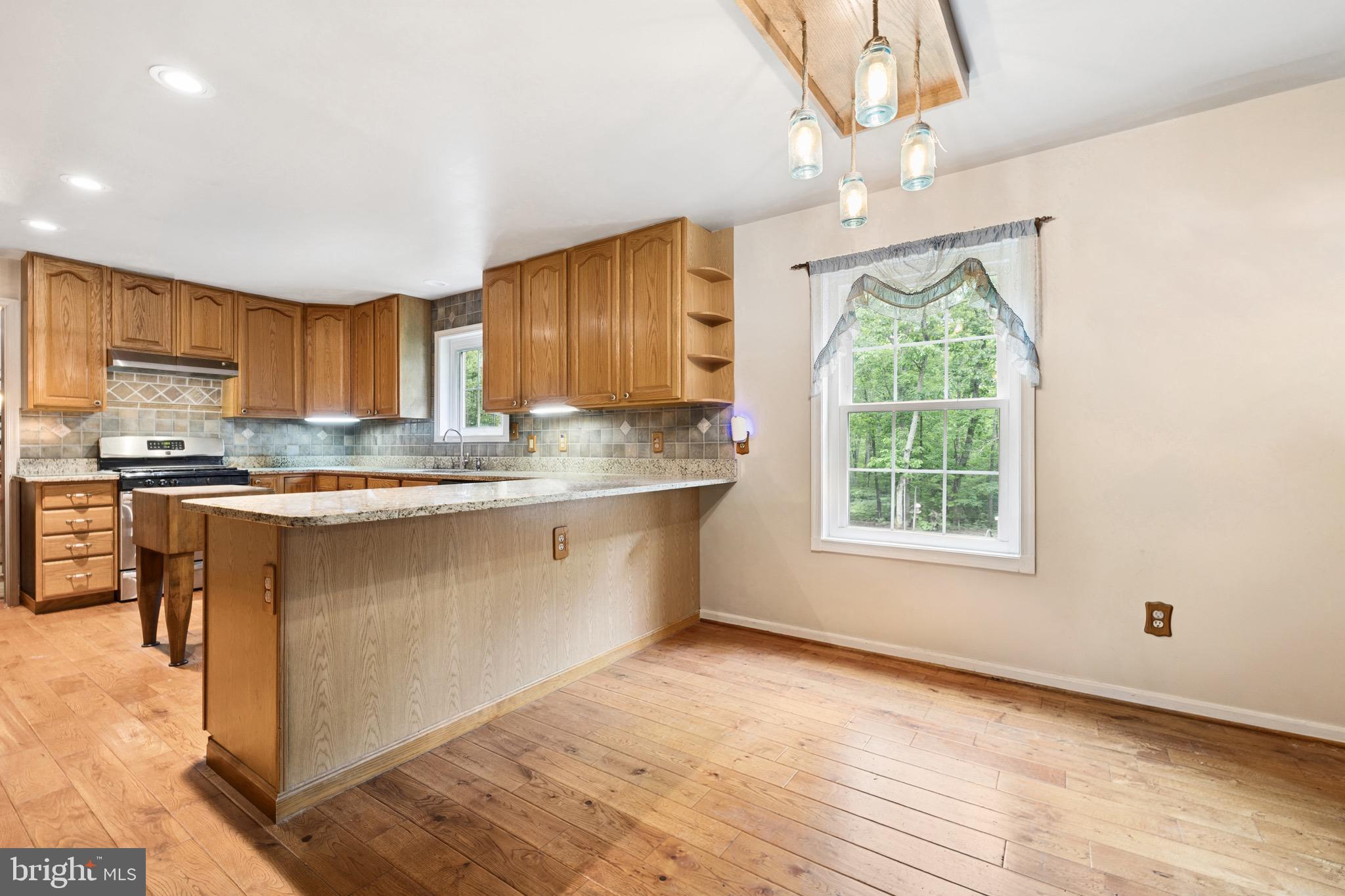 5099 Courtneys Corner Road Sumerduck, VA 22742 - Photo 15 of 73 a kitchen with stainless steel appliances granite countertop a stove a sink dishwasher and a refrigerator with wooden floor