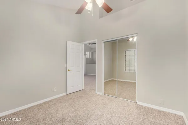 an empty room with a ceiling fan and a window