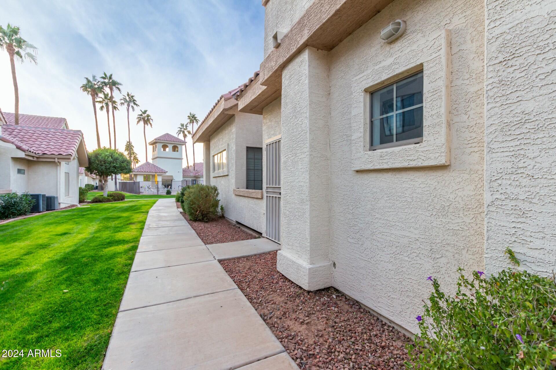 2801 North Litchfield Road, Unit 18 Goodyear, AZ 85395 - Photo 2 of 21 a view of a house with a yard and flower plants