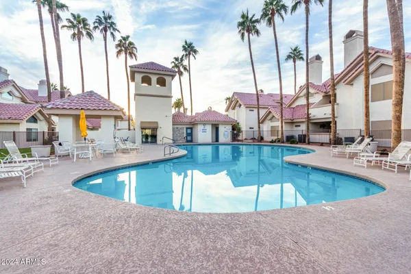 a view of a swimming pool with a patio and a yard