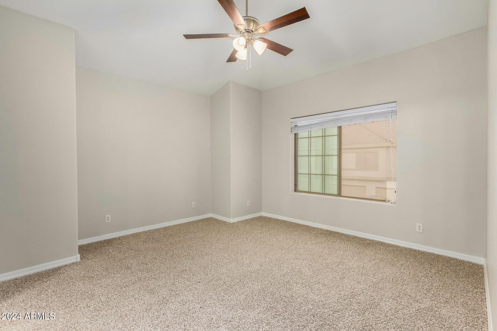 2801 North Litchfield Road, Unit 18 Goodyear, AZ 85395 - Photo 9 of 21 an empty room with a window and a fan