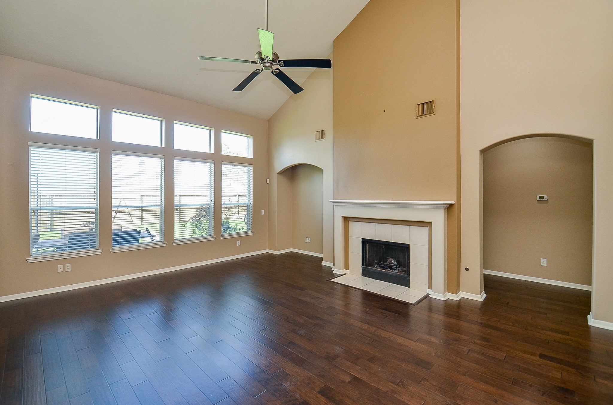 1222 Ragsdale Lane Katy, TX 77494 - Photo 7 of 31 Two story family room with hardwoods has a gas log fireplace and a wall of windows providing abundant natural lighting.