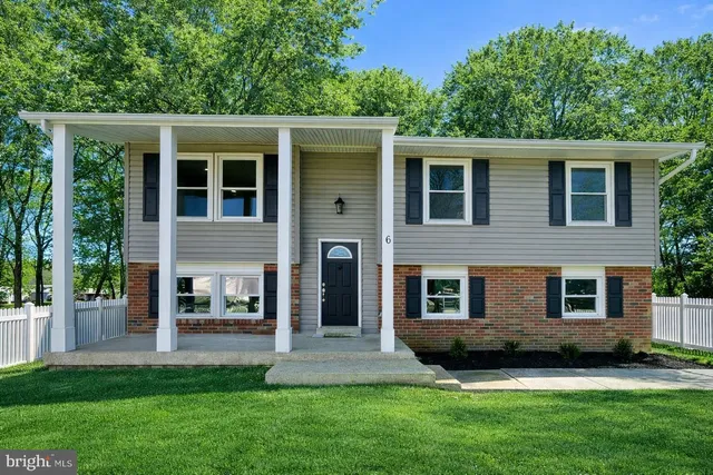a front view of a house with a yard and green space
