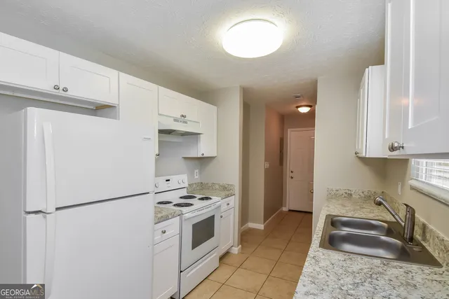 a kitchen with stainless steel appliances a refrigerator sink and stove