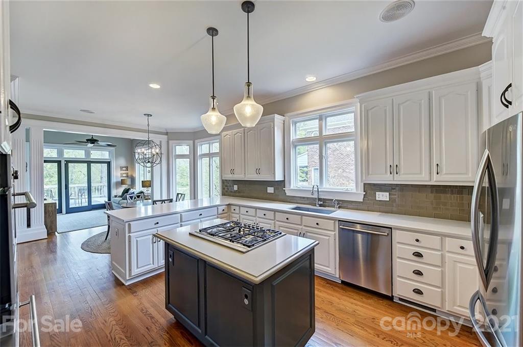 18731 River Falls Drive Davidson, NC 28036 - Photo 3 of 45 a kitchen with a stove a sink dishwasher a refrigerator and cabinets with wooden floor