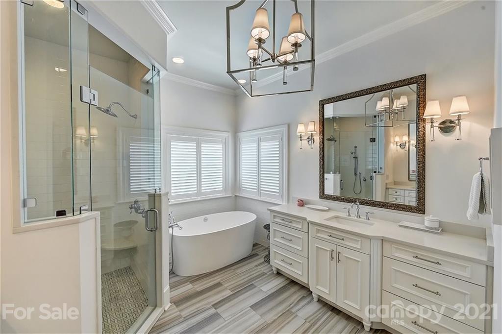 18731 River Falls Drive Davidson, NC 28036 - Photo 21 of 45 a bathroom with a double vanity sink a mirror a bathtub and shower