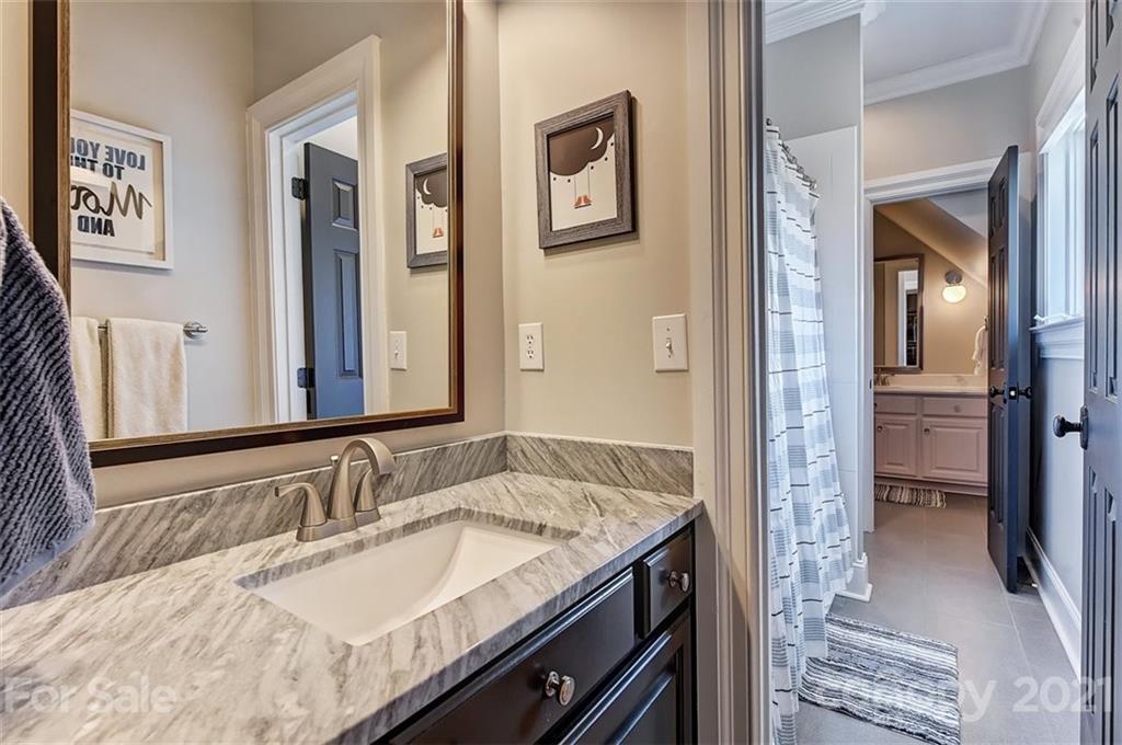 18731 River Falls Drive Davidson, NC 28036 - Photo 28 of 45 a bathroom with a granite countertop sink and a mirror