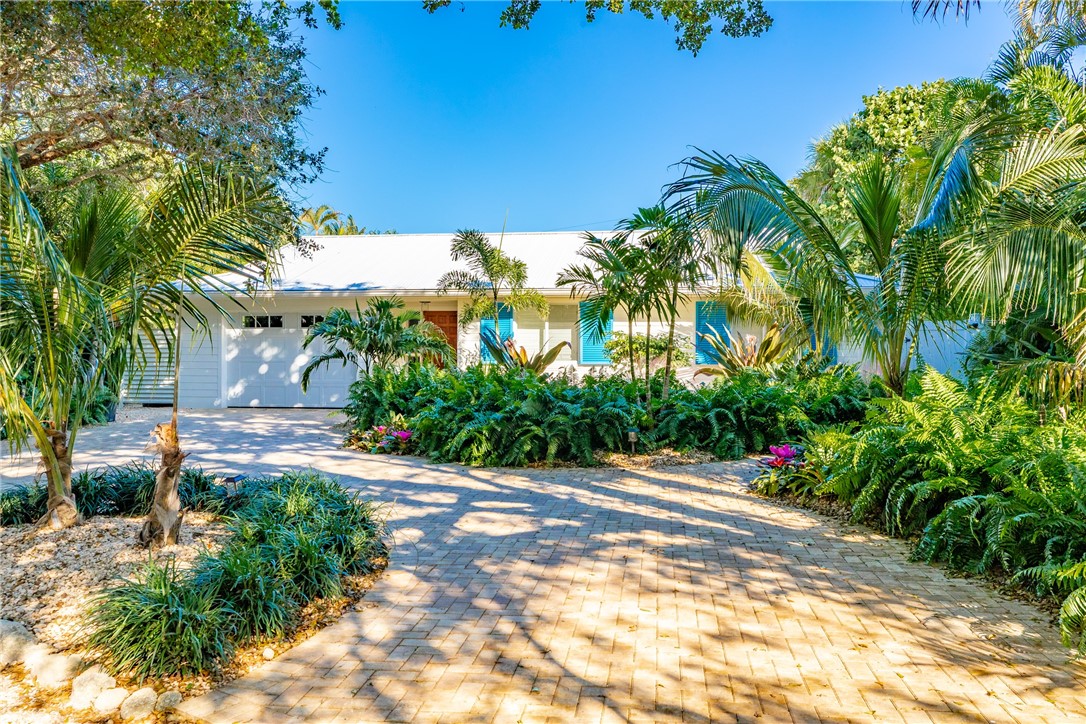 1830 East Sandpiper Road Vero Beach, FL 32963 - Photo 1 of 36 a wooden fence with some potted plants in front of house