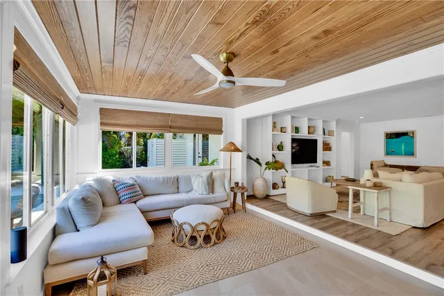 a living room with furniture a flat screen tv and a large window