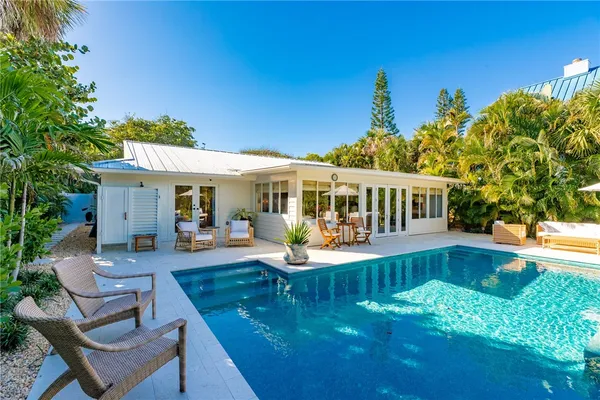 a view of a house with swimming pool and sitting area