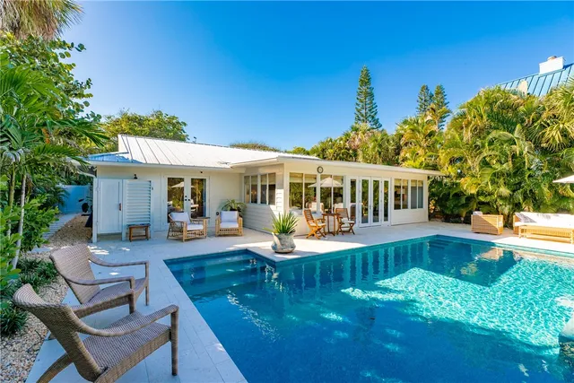 a view of a house with swimming pool and sitting area
