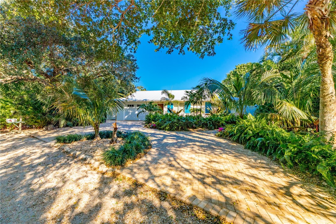 1830 East Sandpiper Road Vero Beach, FL 32963 - Photo 32 of 36 a view of a yard with plants and a large tree