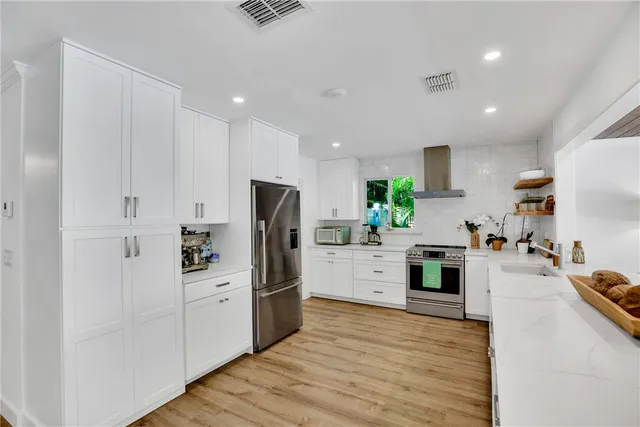 a kitchen with white cabinets and stainless steel appliances