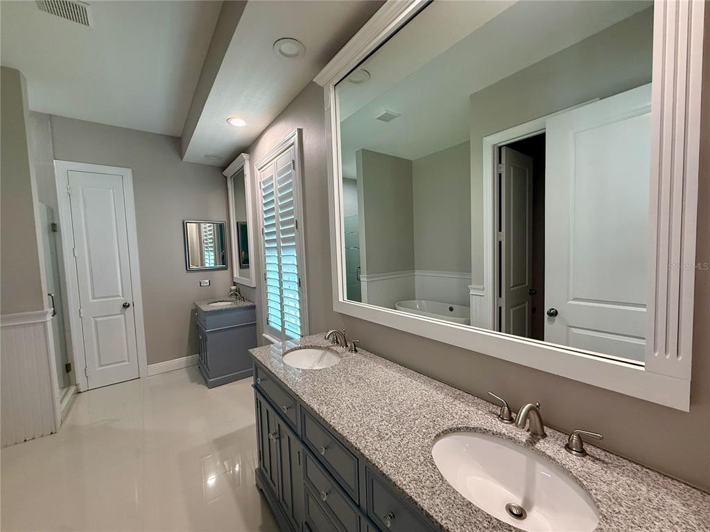 1328 Celebration Avenue Celebration, FL 34747 - Photo 17 of 26 a bathroom with a granite countertop sink and a mirror
