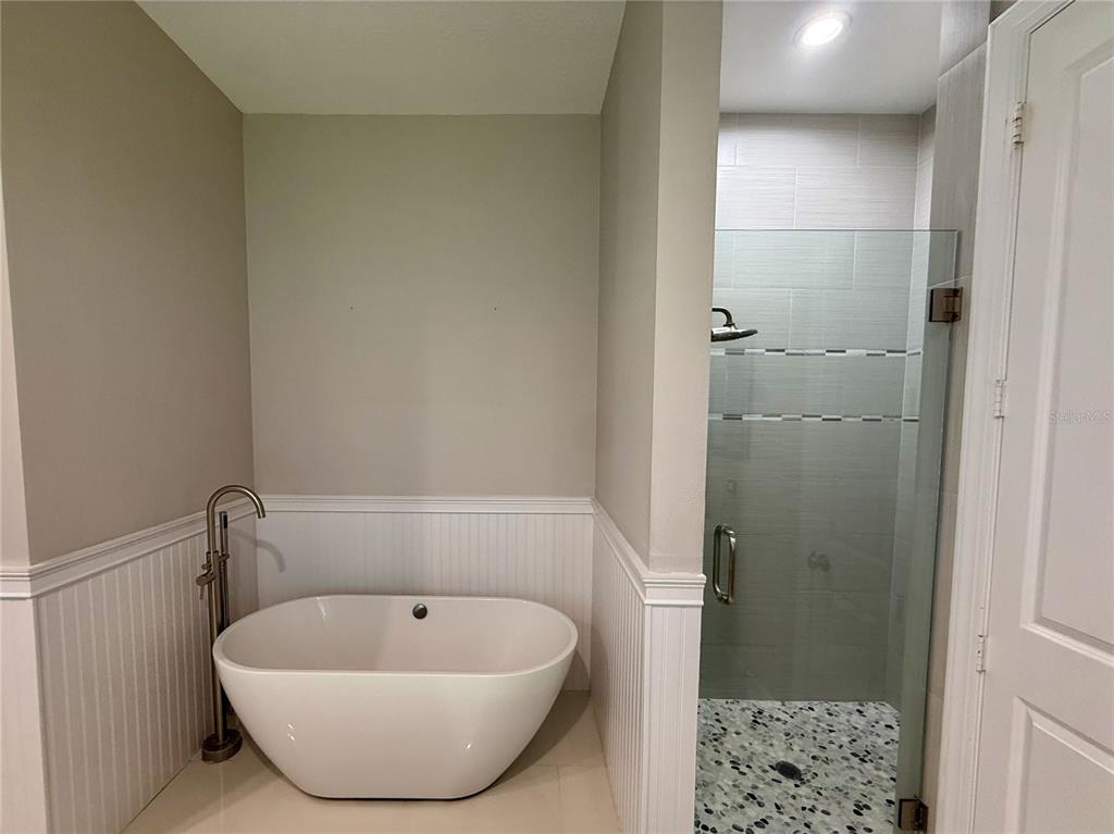 1328 Celebration Avenue Celebration, FL 34747 - Photo 18 of 26 a bathroom with a bathtub and shower