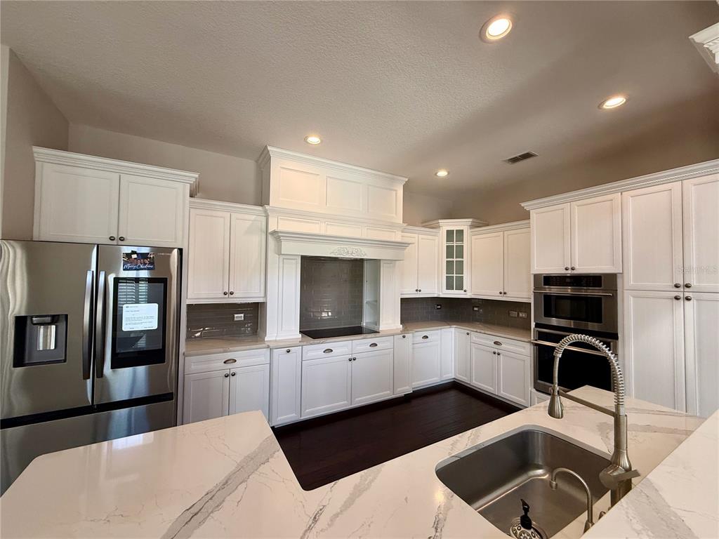 1328 Celebration Avenue Celebration, FL 34747 - Photo 7 of 26 a kitchen with granite countertop a stove a sink and a microwave