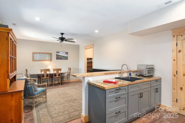 a kitchen that has cabinets a sink dishwasher and a stove with wooden floor