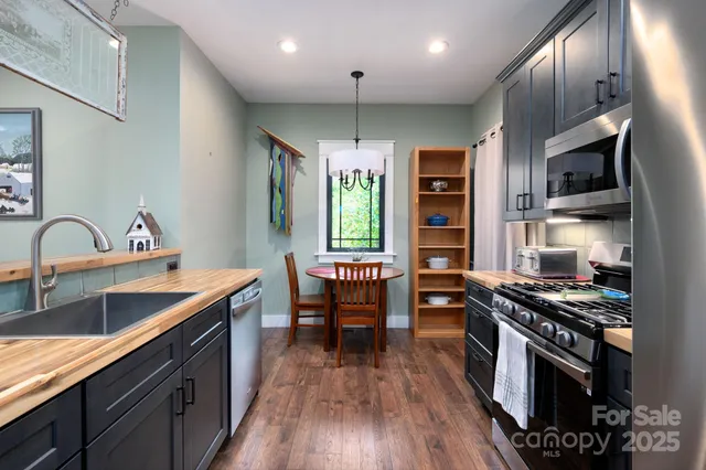 a kitchen with stainless steel appliances kitchen island granite countertop a stove a sink and a refrigerator