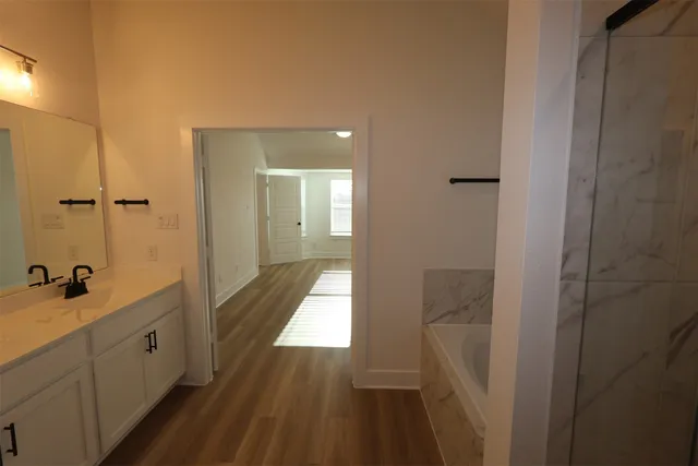 a bathroom with a sink and mirror with shower