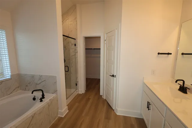a bathroom with a tub sink and mirror