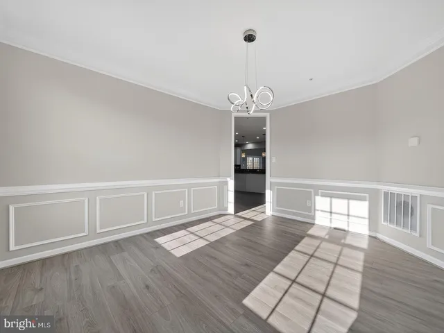 a kitchen with stainless steel appliances kitchen island wooden floors and white cabinets