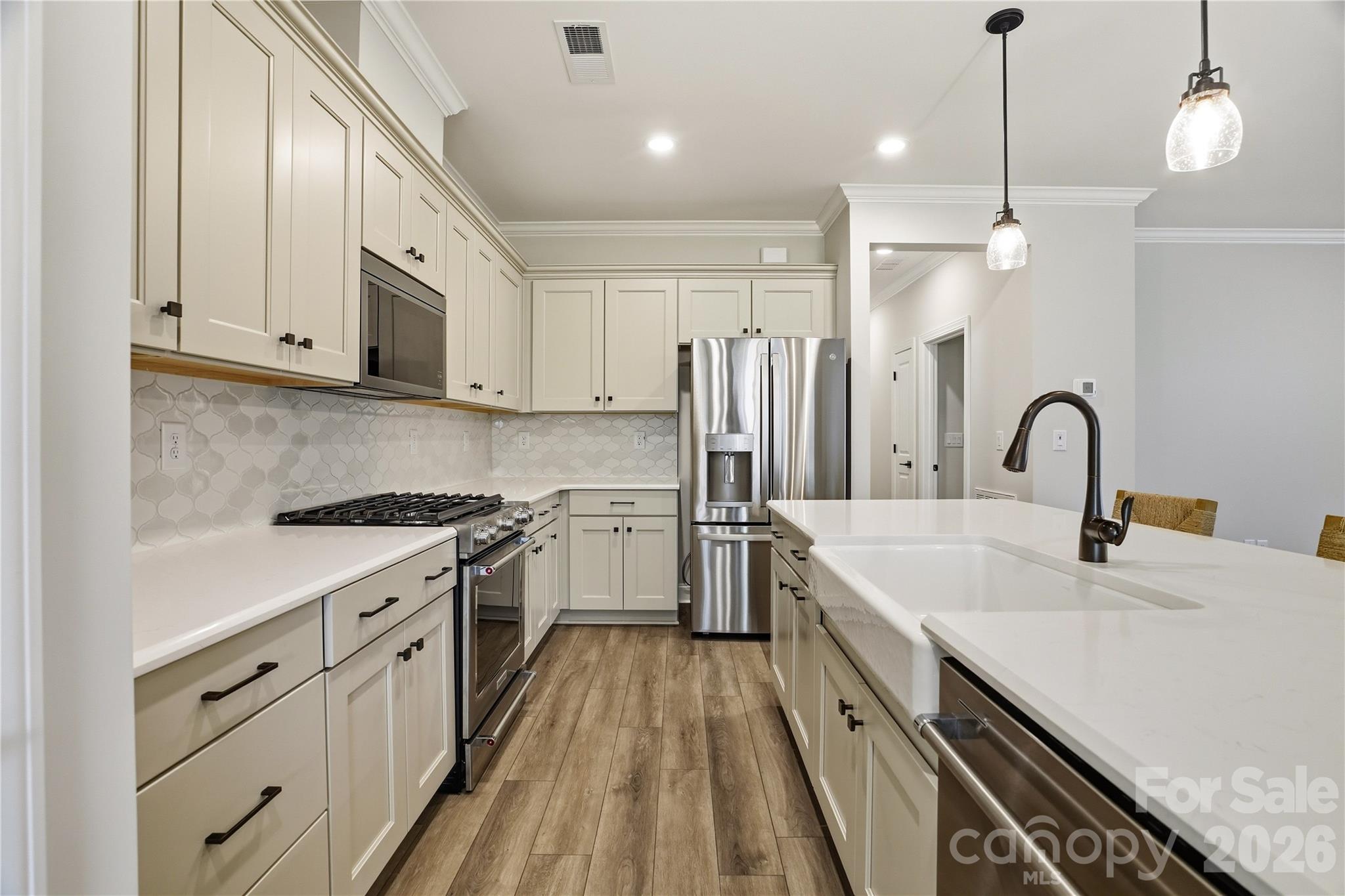 5562 Caneel Lane Denver, NC 28037 - Photo 11 of 44 a kitchen with white cabinets appliances and sink