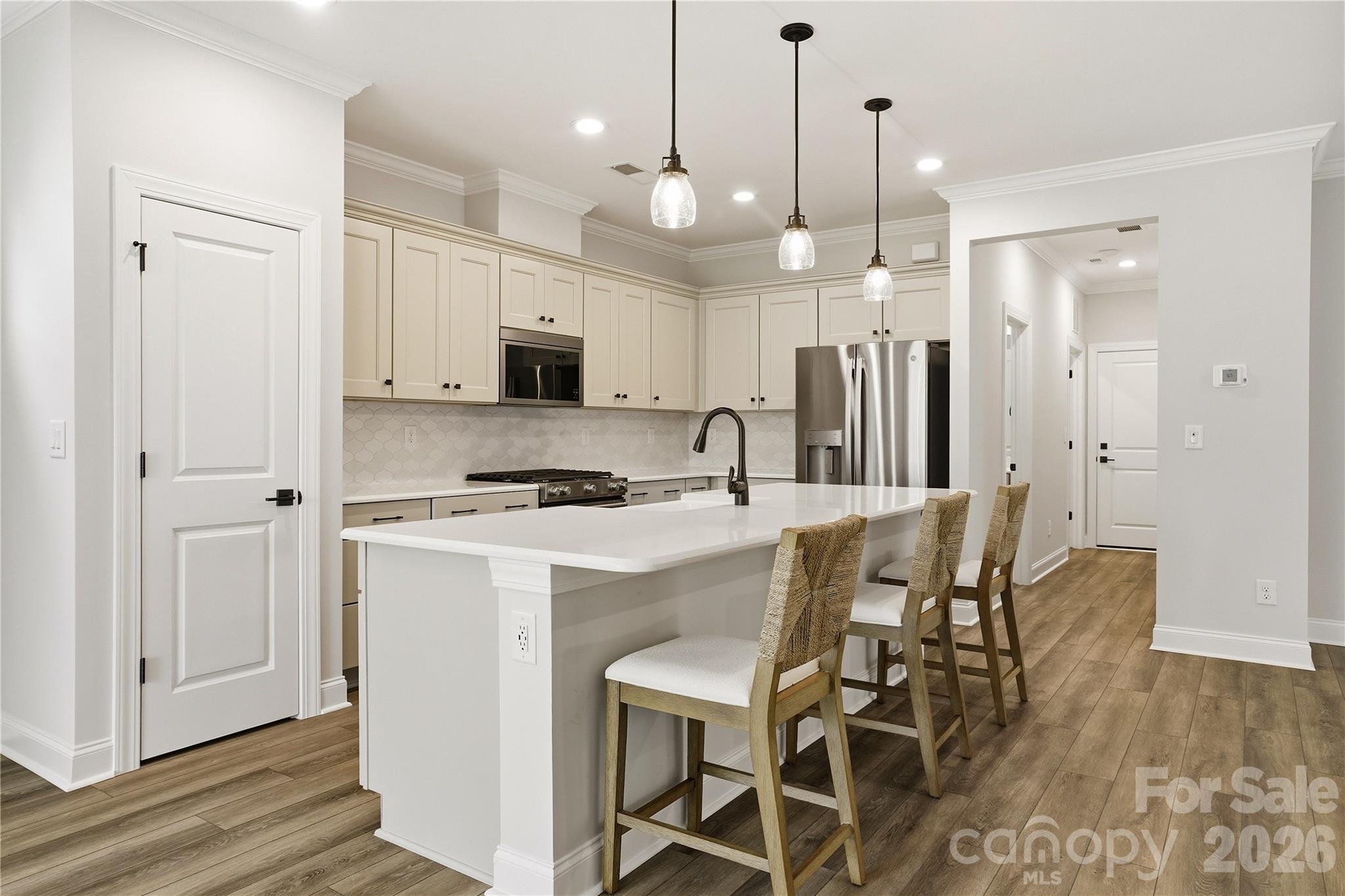 5562 Caneel Lane Denver, NC 28037 - Photo 10 of 44 a kitchen that has a lot of white cabinets and stainless steel appliances