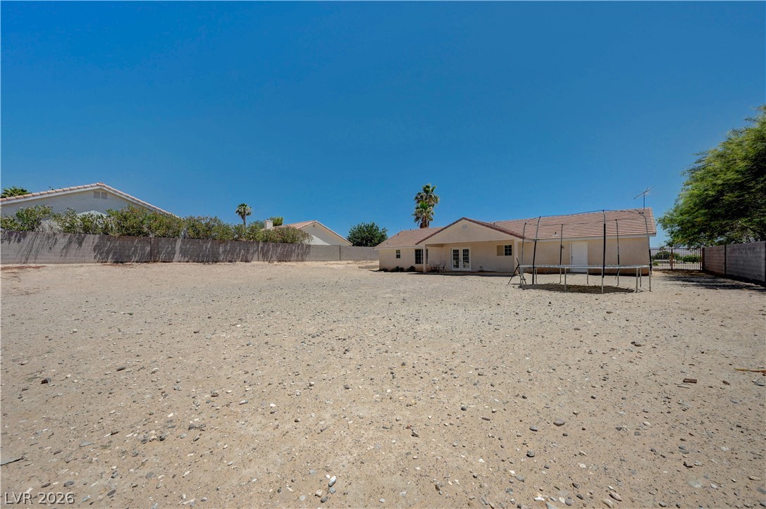 1272 Liston Avenue Logandale, NV 89021 - Photo 46 of 61 A spacious desert backyard offers ample room for outdoor recreation and potential landscaping.