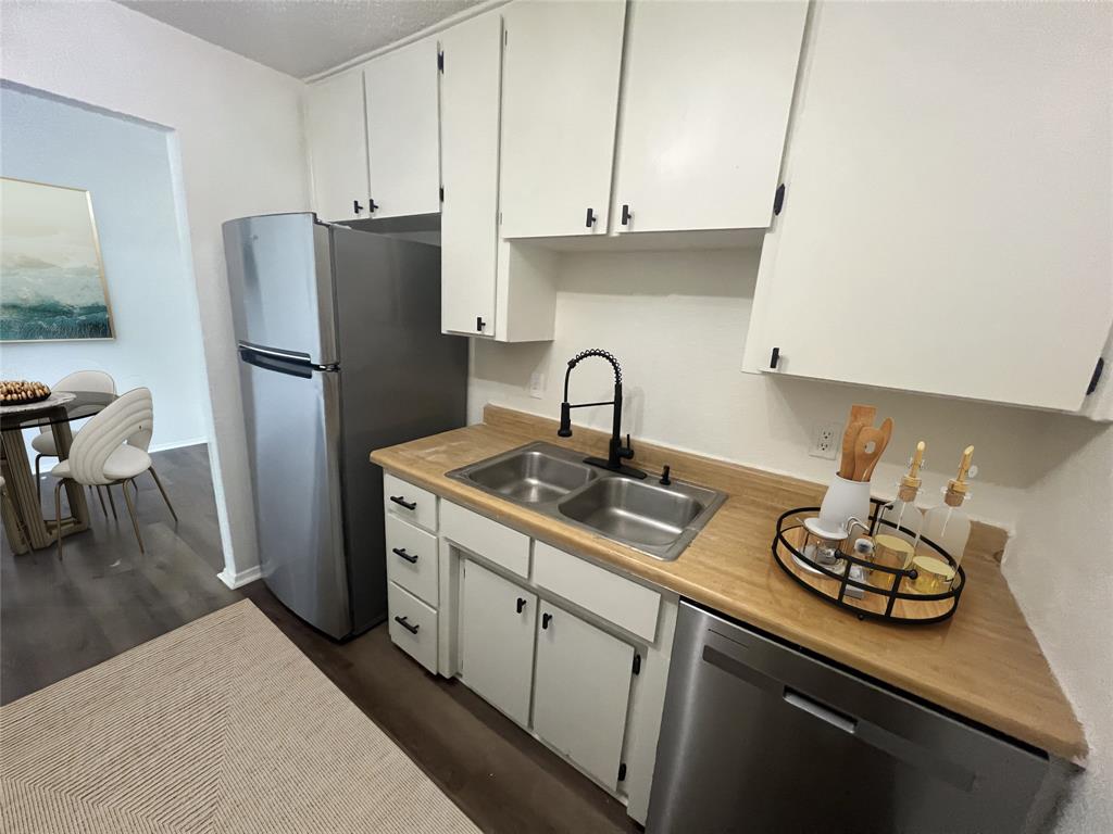 4639 Williams Road, Unit 118 Benbrook, TX 76116 - Photo 4 of 13 Kitchen with stainless steel appliances, light countertops, dark wood-type flooring, and white cabinetry