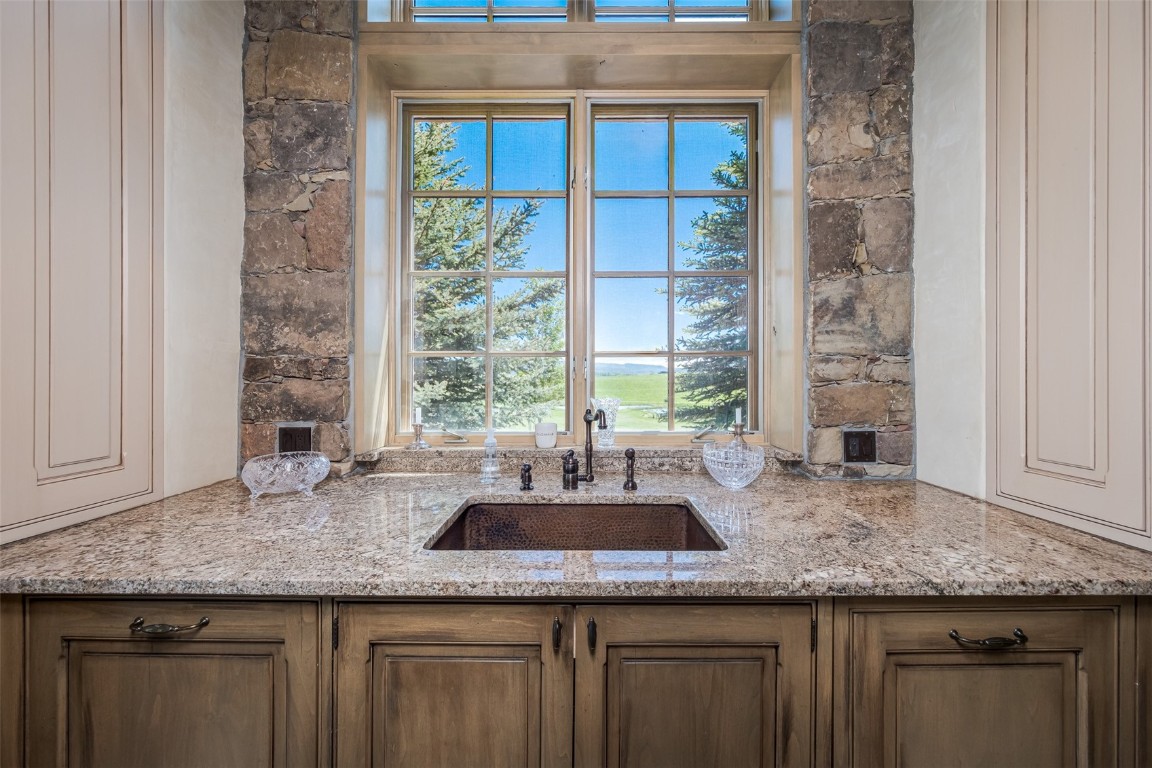 30855 Emerald Ridge Steamboat Springs, CO 80487 - Photo 12 of 50 a kitchen with granite countertop kitchen island a sink a counter and a window