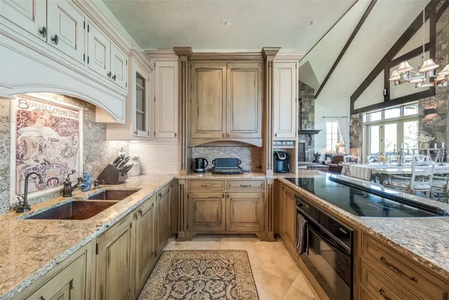 a kitchen with granite countertop a sink and a wooden floors