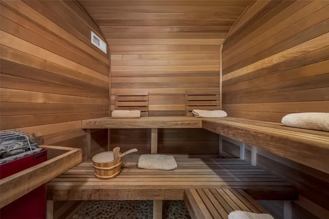 a spacious bathroom with a granite countertop double vanity sink a mirror and a bathtub