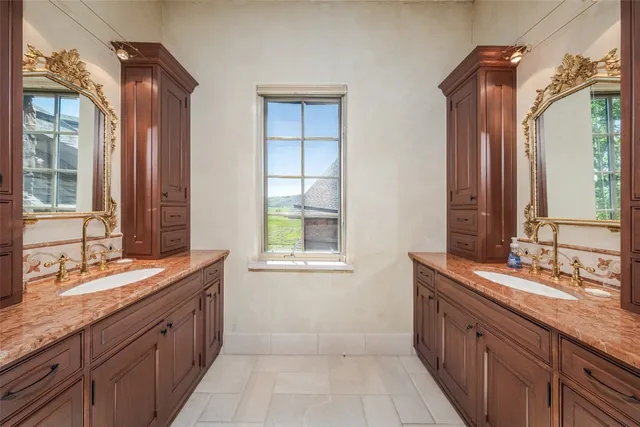 a bed sitting in a spacious bedroom next to a window
