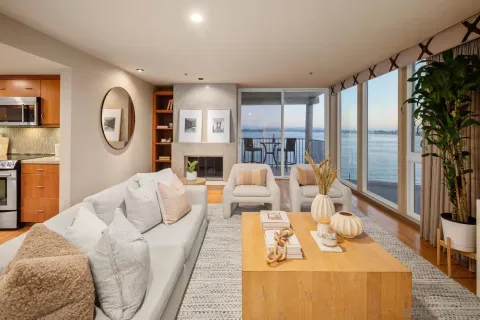 a living room with furniture fireplace and a large window