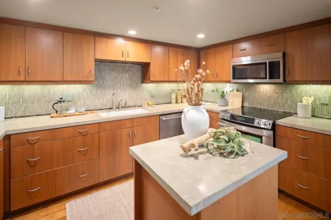 a kitchen with kitchen island stainless steel appliances a sink stove and refrigerator