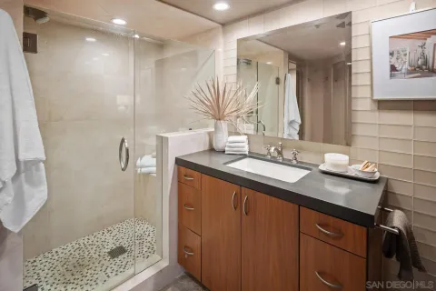 a bathroom with a granite countertop sink toilet and shower